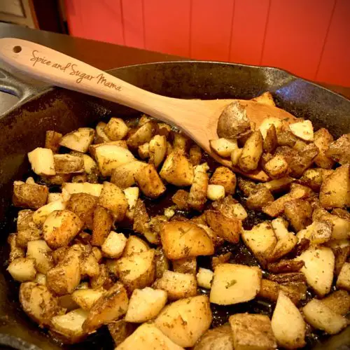 skillet breakfast potatoes cooking stovetop in castiron