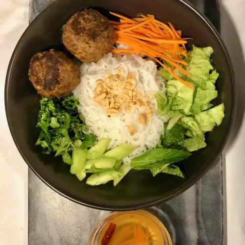 overhead photo of thai meatballs in a vietnamese bun bowl and served with vietnamese fish sauce with shredded carrots